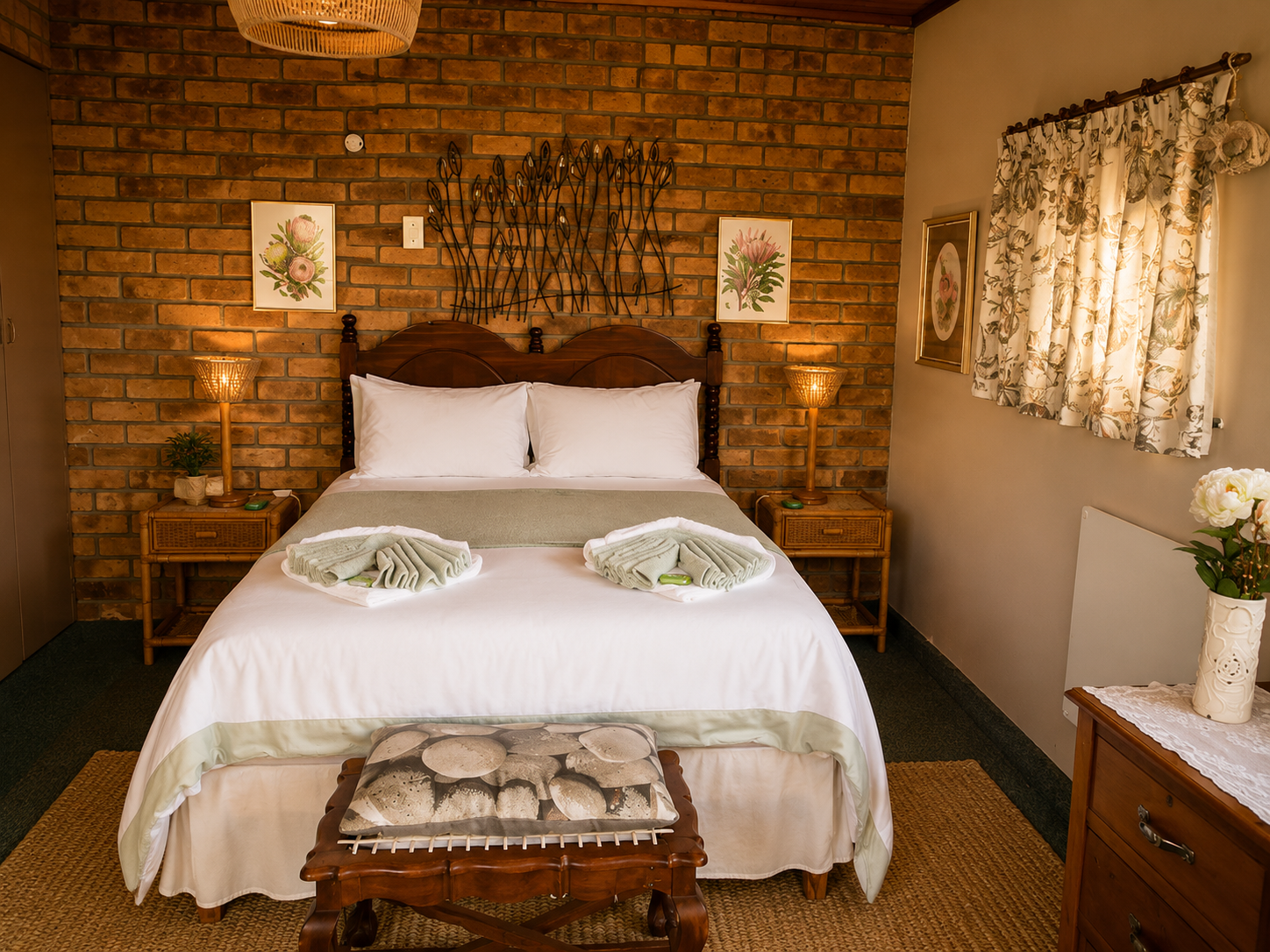 Double bedroom in the Protea Suite with white linen, rattan bedside tables and warm brick feature wall